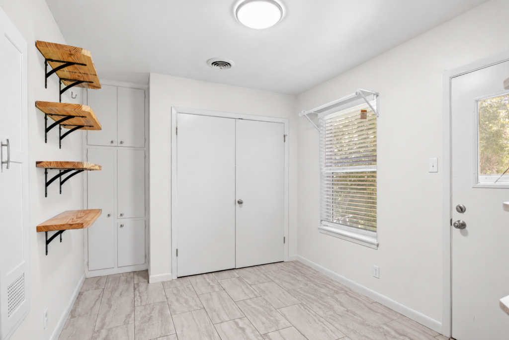 Entry area with floating wood shelves, closet doors and side entrance
