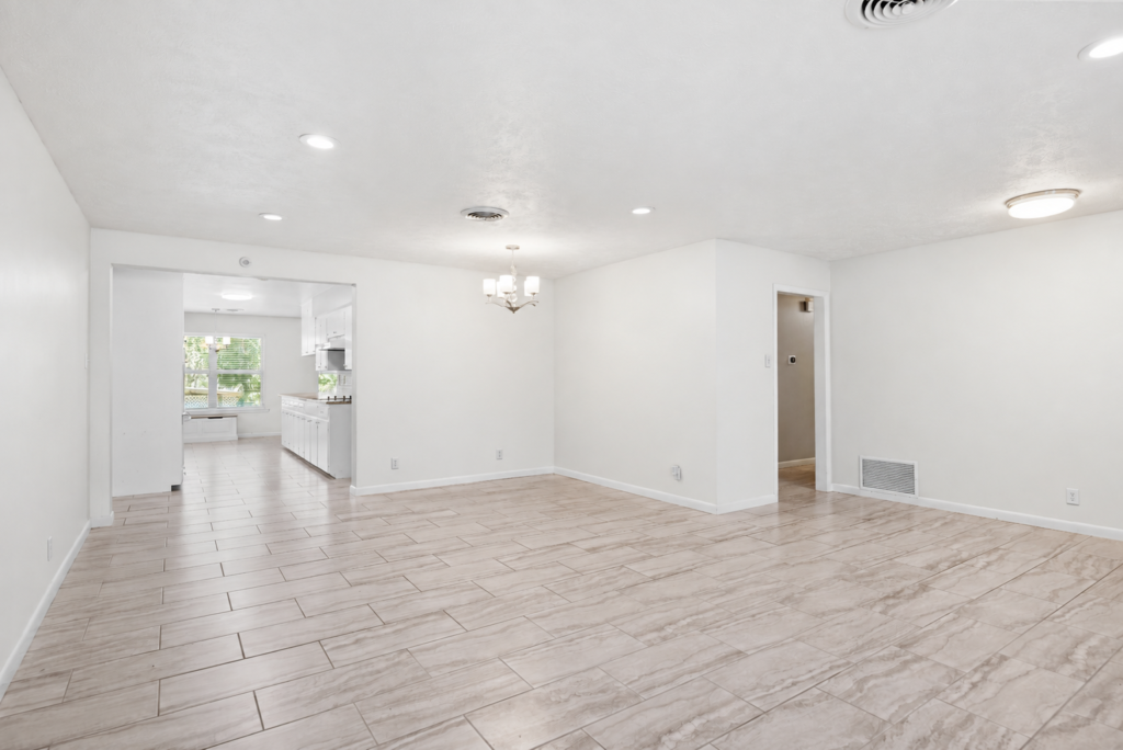 Open living room in soft white with a view through to the kitchen