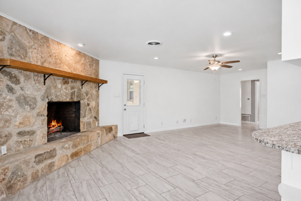 Family room centered on the rock fireplace with fresh white walls