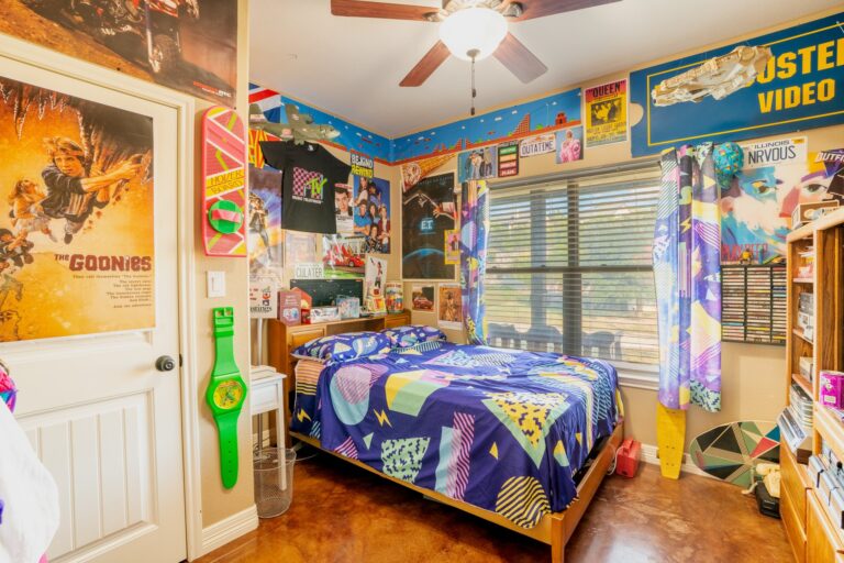 Second bedroom with ceiling fan and stained concrete floors at 119 Fannin Drive, Kerrville