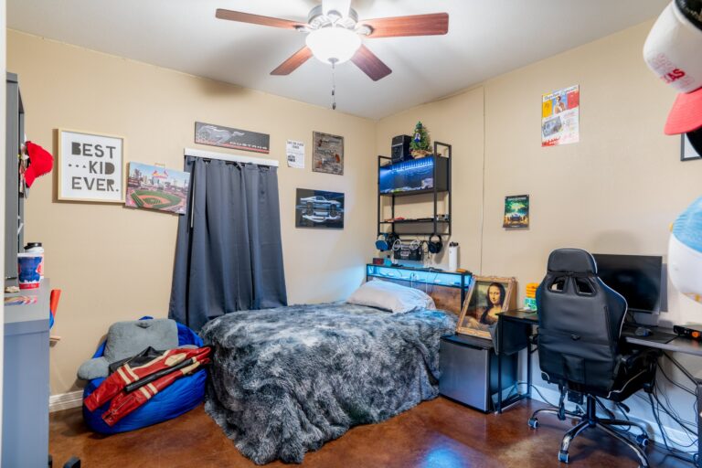 Third bedroom with ceiling fan and stained concrete floors at 119 Fannin Drive, Kerrville