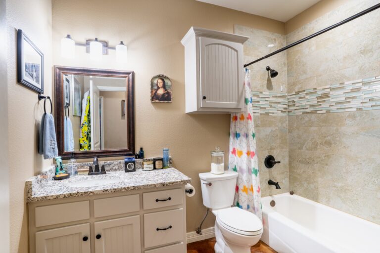 Second full bath with granite vanity and a tiled tub and shower at 119 Fannin Drive, Kerrville